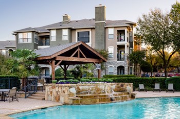 pool with fountain and exterior of apartment building